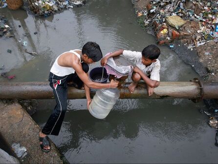 Two kids collecting water from polluted source