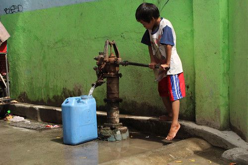 A little boy obtaining freshwater from a deepwell in the Philippines for everyday use 