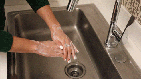 A woman washing her hands thoroughly with clean water and soap to maintain good personal hygiene