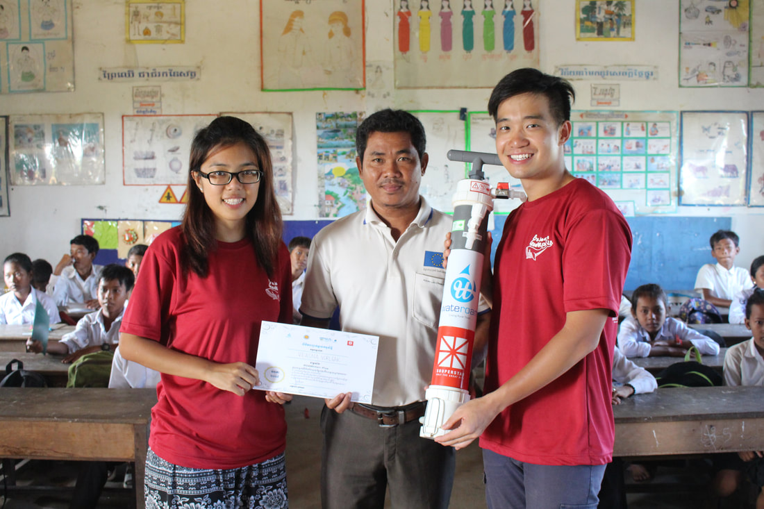 Wateroam and OceaNUS representatives presenting a certificate to a school principal in Cambodia