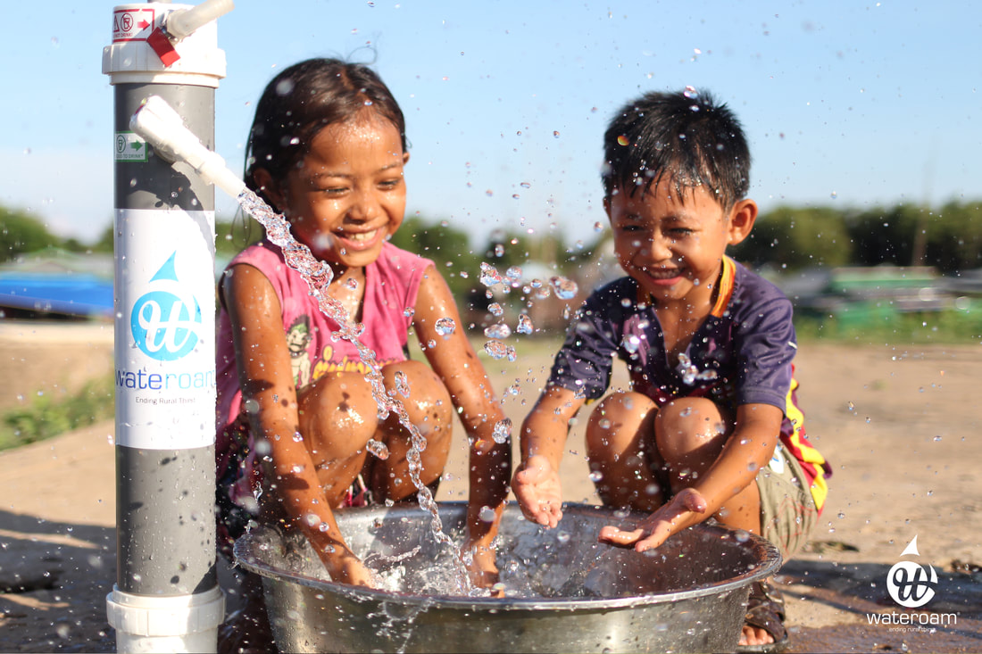Two happy children playing water from WateROAM ROAMfilter™ Plus